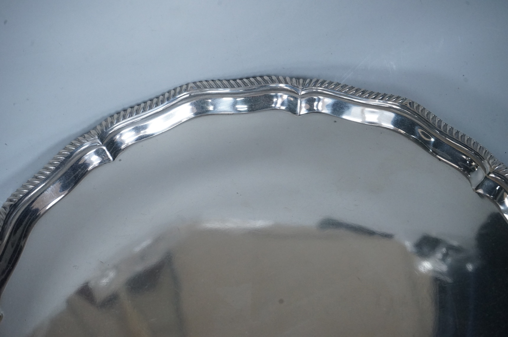 A George V silver salver, of shaped circular form, with gadrooned border, on four claw and ball feet, Thomas Bradbury & Sons, Sheffield, 1918, diameter 30.8cm, 27.2oz.